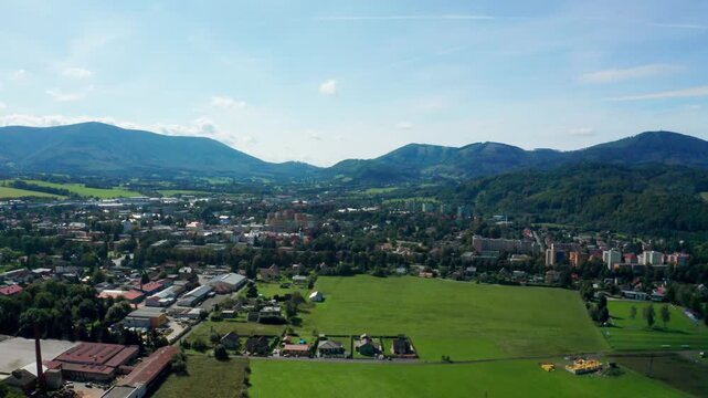 Left side drone shot of czech small city with beskydy mountains