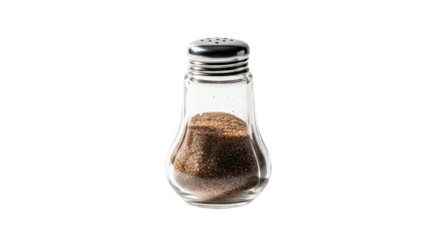 Salt shaker with brown grains stands on black background. Condiment, seasoning, cooking, glass, kitchen, table.