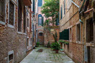 Narrow alley with brick buildings and potted plants