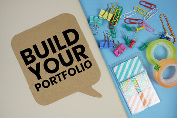 Build Your Portfolio text with stationery on cover notebook background