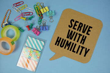 Serve With Humility text with stationery on blue background