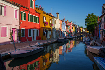 Colorful buildings along a canal with boats in Burano