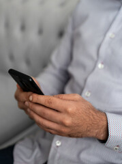  Man in business shirt holding smartphone, checking messages. Concept of communication, business and modern technology.