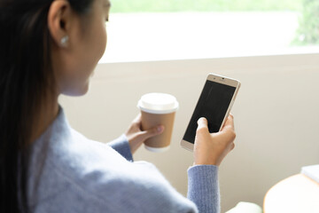 Young Asian woman enjoying a peaceful moment reading a book near window. Calm lifestyle, self-learning, and mindfulness at home.