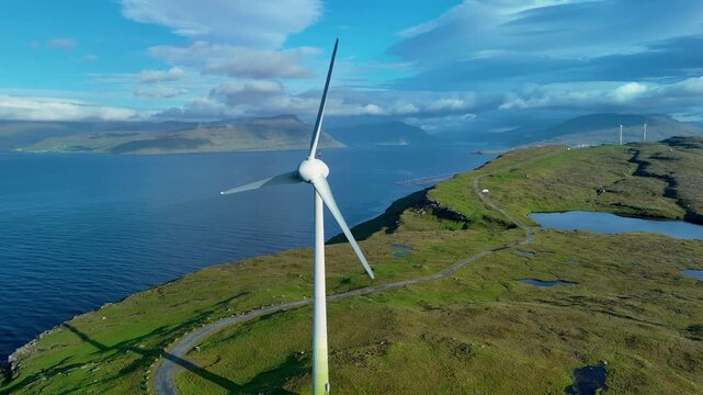 Experience the stunning natural beauty of the Faroe Islands, featuring majestic wind turbines standing against a backdrop of vibrant green hills and serene blue waters huge windmills green energy