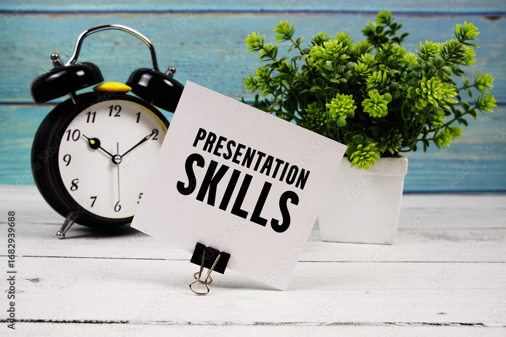 Poster presentation skills text written on paper card with alarm clock on wooden background