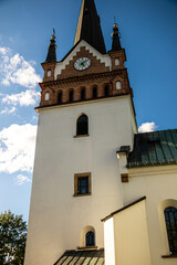 A tall church tower with a clock and a dark spire