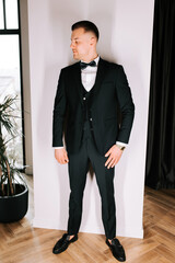 Smartly dressed man posing in a modern interior setting during a formal event