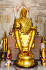 sacred golden buddha statue seated in holy position at monastery