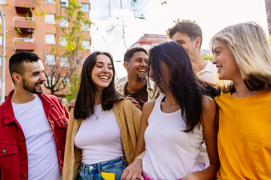 Diverse group of young friends having fun together outdoors during summer vacation. Youth and friendship concept