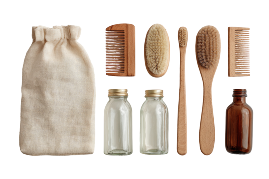Natural, eco-friendly personal care items arranged in a set.  A cream-colored drawstring bag sits beside wooden brushes, glass jars, and a small amber bottle