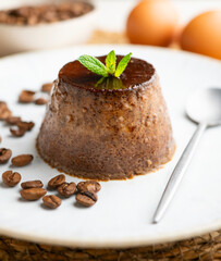 Homemade chocolate and coffee flan decorated with fresh mint. Traditional egg recipe.