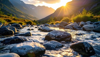 Obraz premium Sunburst over rocky river winding through mountain valley. Lush green slopes meet distant snow-capped peaks under a golden sky