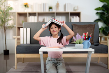 Back to School. Child playfully balancing books on head while studying.