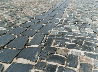 Fototapeta premium A road paved with large cobblestones, close-up. Background