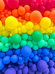 A spectacular wall of multicolored inflatable balloons creates a vibrant rainbow backdrop, symbolizing LGBTQ+ pride and diversity celebration. Perfect for event decorations, social media content.