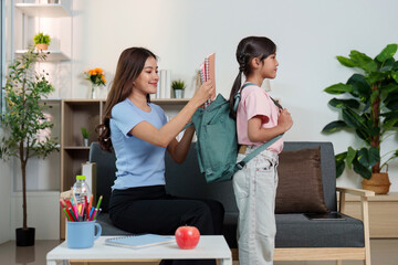 Back to School. Parent assisting child with backpack and school supplies.