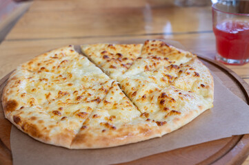 Tasty Cheese Pizza Served on a Wooden Board Accompanied by a Drink