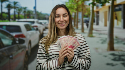 Woman holding icelandic krona banknotes on a street with cars and trees, showing outdoor urban...