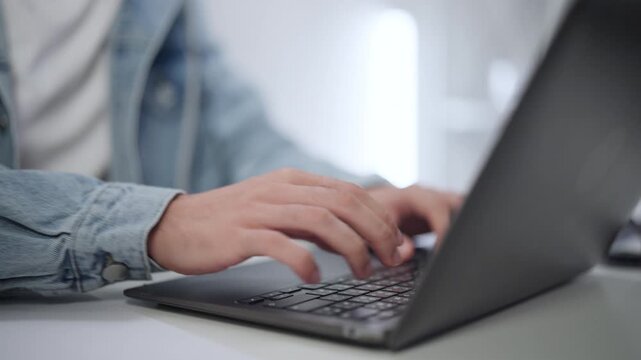 Close-up of Hands Typing Code on Laptop Keyboard, Highlighting Remote Work and Software Development