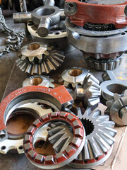 A vibrant display of various metal gears and differential components with red accents, This image...