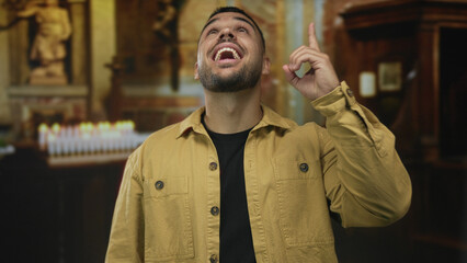 Man points finger upward in historic stone church interior under flickering candles; faith hope...