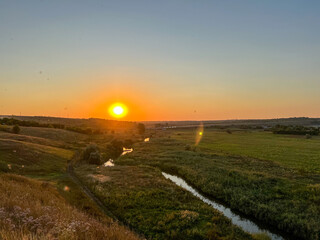 Breathtaking sunset illuminating winding river through green valley