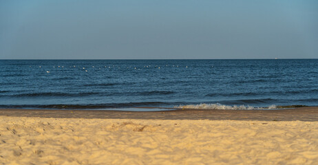 Light sand, sea with seagulls, and blue sky form three horizontal layers like a flag