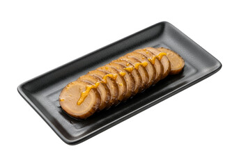 Sliced pickled daikon radish, drizzled with a light mustard sauce, presented on a dark rectangular plate against a black background.