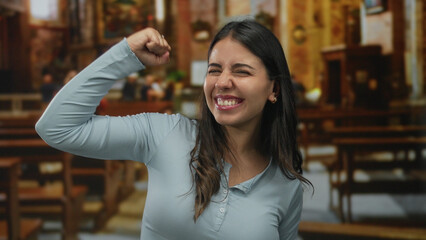 Hispanic woman expressing joy inside a beautifully lit church, showcasing a lively spirit in a...