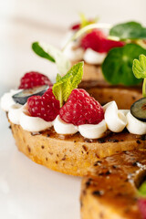 Elegant raspberry tart with whipped cream and fresh mint garnish