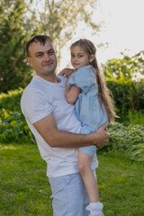 Obraz premium A father holds his daughter in his arms. The concept of family and the relationship between a father and his daughter.