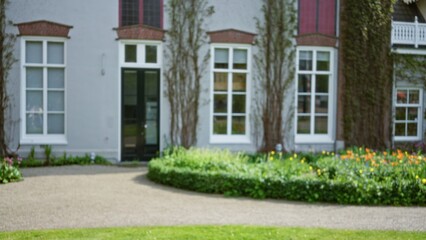 Blurred house facade in amsterdam with bokeh effect featuring windows, greenery, and a garden path showcasing urban charm in the netherlands cityscape.