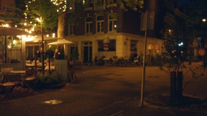 European evening scene with blurred lights and bokeh effect capturing an outdoor cafÃ© terrace in a city setting.