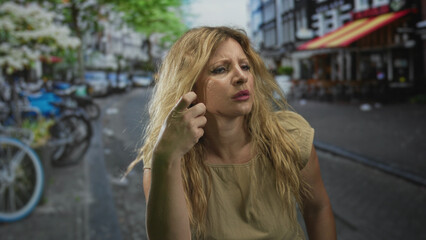 Woman with hands raised palms up on a busy city street in a questioning gesture, hands open and...