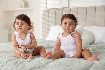 Cute little twin babies on bed at home
