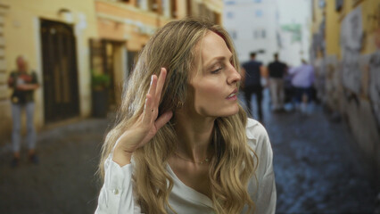 Woman raises hand for knocking start on street as young blonde peers at glass, listening intently...