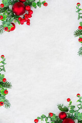 Snowy fir branches, red berries and red christmas balls on white snow background with space for text. Christmas and winter. Flat Lay, top view