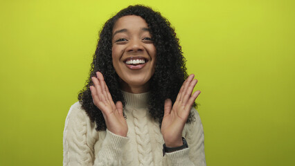 Woman wearing a cable knit sweater smiling and showing teeth in studio with lime green background;...