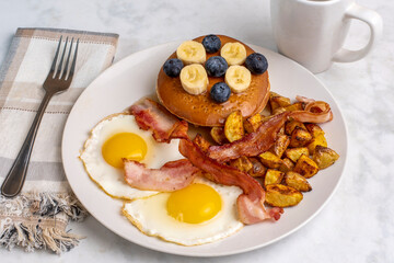 fried eggs with pancakes  with blueberries and bananas