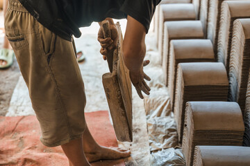 Manual clay tile making with worker shaping, drying and organizing terracotta in traditional workshop showing heritage craft and raw material process