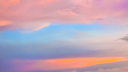 Vibrant pink, purple, and blue pastel sunset sky with flufy clouds. A beautiful abstract background for dreams, relaxation, and romance.