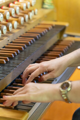 A female musician plays a piece on an antique wooden organ