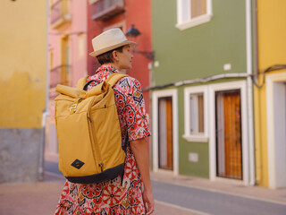 Woman in dress strolls through colorful streets of Spanish coastal town of La Vila Joiosa . sunny...