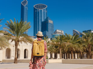 Young woman exploring Qasr Al Hosn Park in Abu Dhabi. Surrounded by lush greenery and historical landmarks, she enjoys the serene atmosphere and Emirati heritage in heart of city.