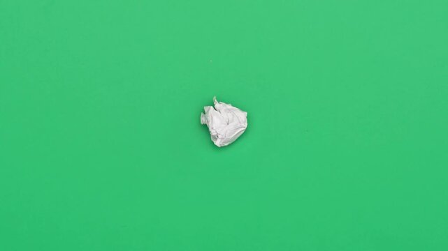 Stop motion animation of crumpled pape on a green background