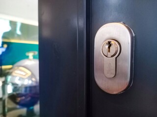 Close-up of a metallic door lock on a dark surface, highlighting the keyhole detail, suitable for...