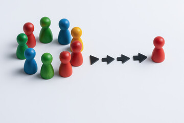 Leadership talent search recruitment circle of wooden game pieces pointing arrows to isolated pawn