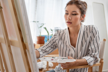 beautiful female hobbies about artist and use paintbrush in abstract art for create masterpiece. painter paint with watercolors or oil in studio house. enjoy painting as hobby, recreation, inspiration