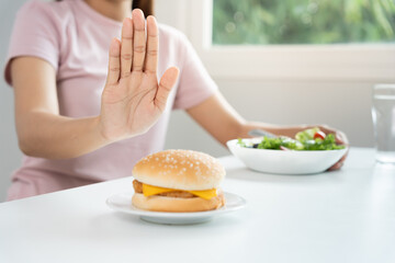 Beauty slim female body confuse hamburger. Woman in restaurant achieves weight loss goal for...